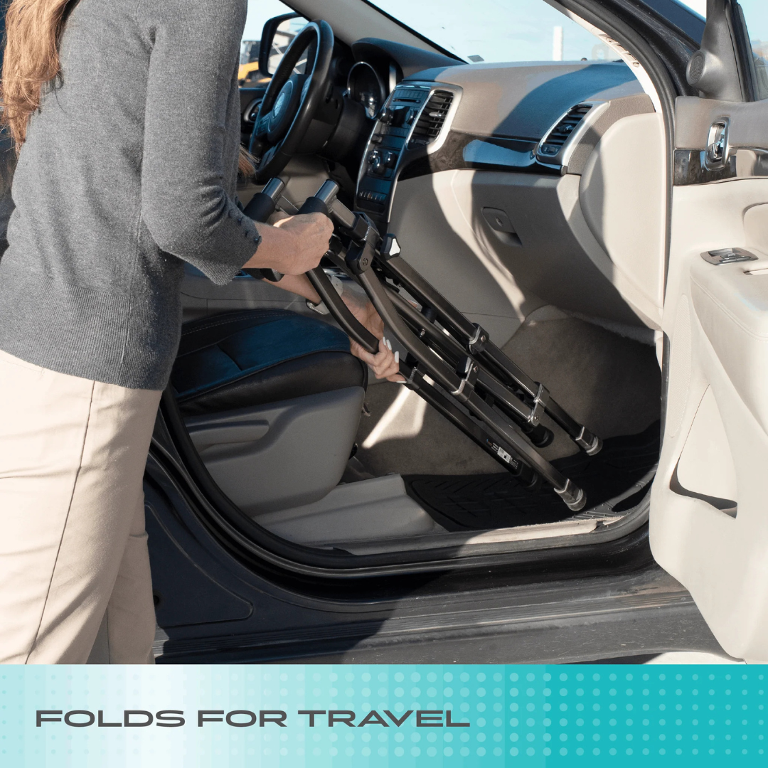 A person places a folded Stander Wonder Walker Lite into the front passenger seat of a car. Text at the bottom reads, FOLDS FOR TRAVEL.