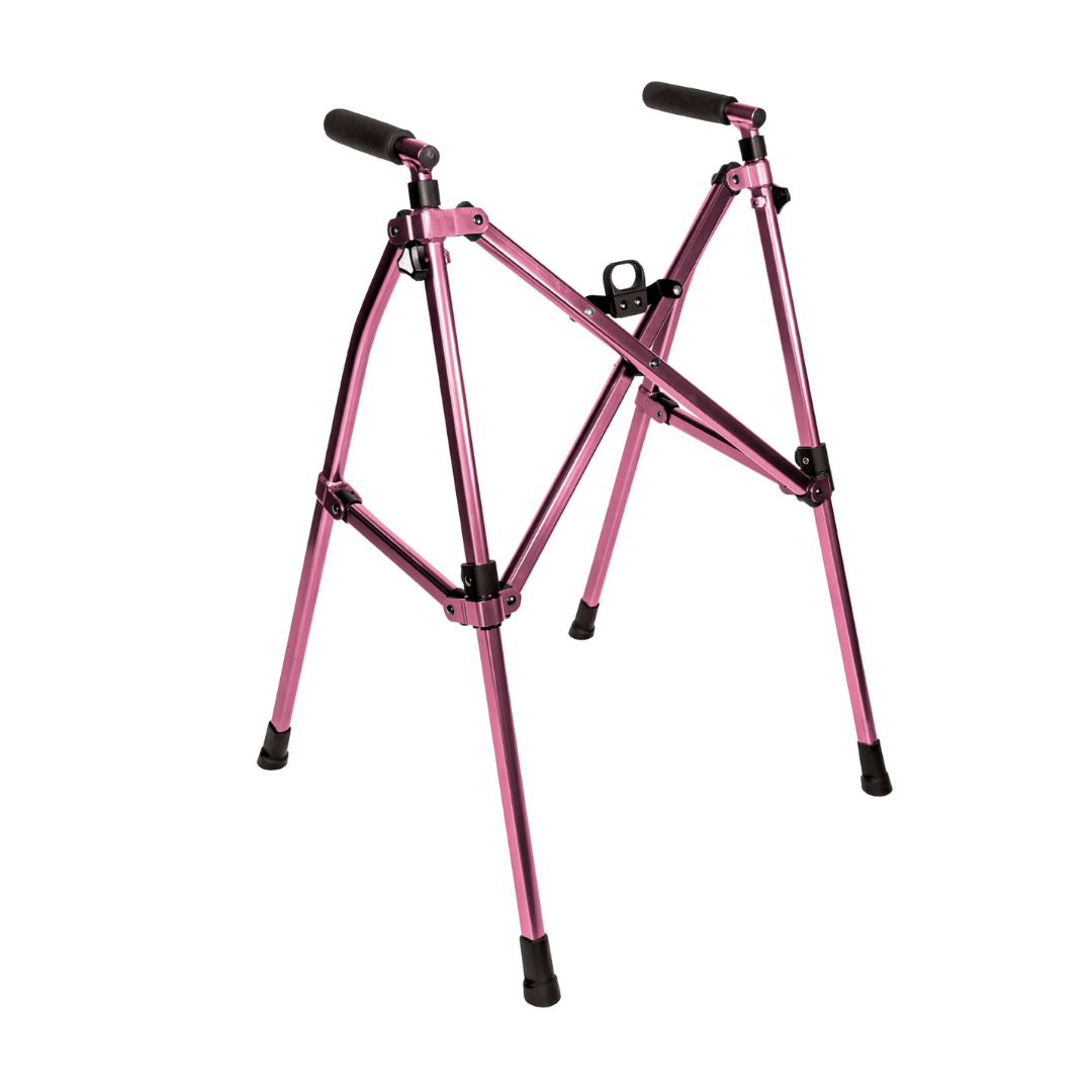 The Stander Wonder Walker Lite, a lightweight and compact folding walker in metallic pink with black rubber handles and feet, stands upright on a white background.