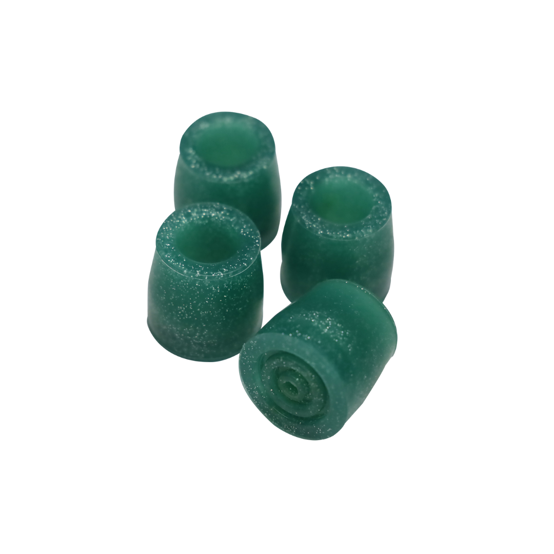 Four green, cylindrical gummy candies with a shiny surface are arranged on a white background, mimicking the sturdy design of the Step2bed Deluxe Bedside Step-Up Platform with Accessory Kit for added support and style.