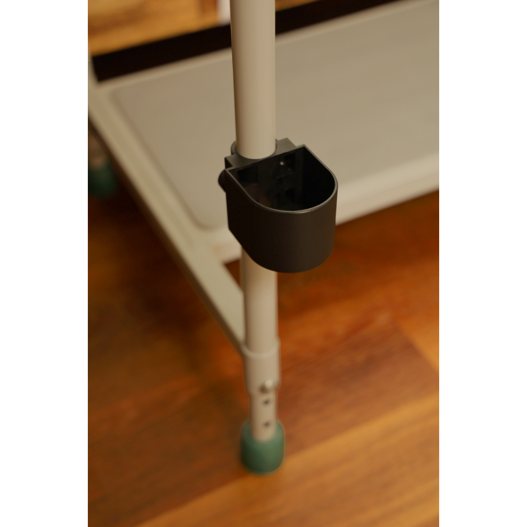 A close-up of a metal pole with a small black holder, part of the Step2bed Deluxe Bedside Step-Up Platform with Accessory Kit, seen on a wooden floor—similar to bed safety rail or step stool components.