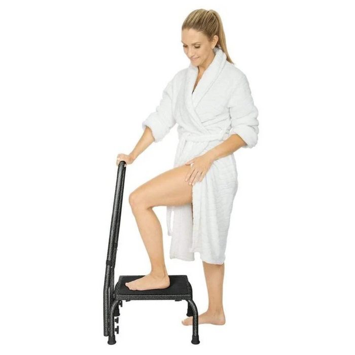 A person in a white bathrobe uses the Vive Health Step Stool, relying on its heavy-duty steel frame for safety. The non-slip platform ensures confidence as they adjust their stance indoors.