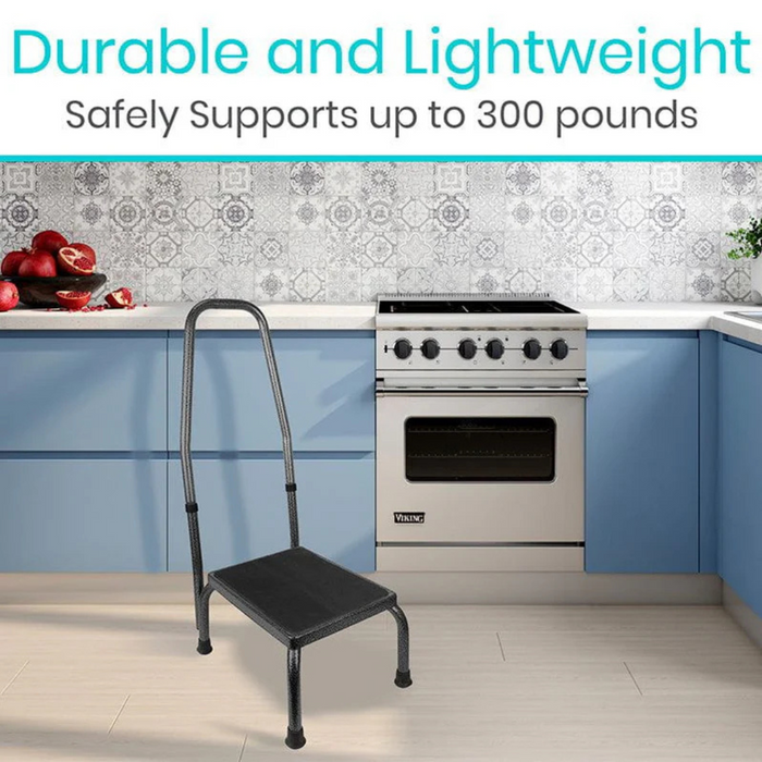 In a modern kitchen with blue cabinets and a silver stove, a black Vive Health Step Stool featuring a durable steel frame and non-slip platform sits by the countertop adorned with pomegranates. Above it reads: Durable and Lightweight; Safely Supports up to 300 pounds.