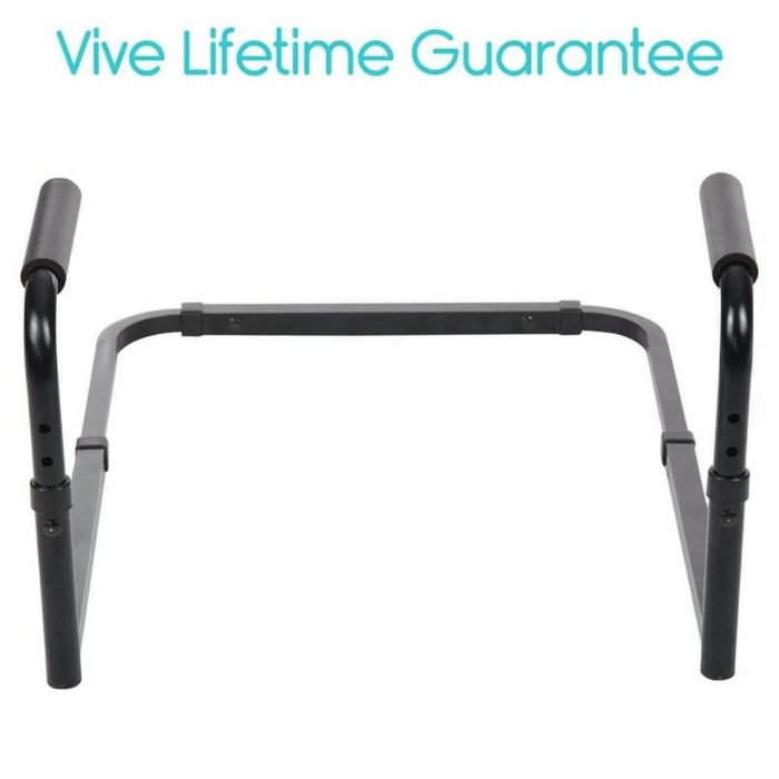 Against a white backdrop, a black adjustable aluminum frame toilet safety rail with padded handles and tool-free assembly is displayed. The blue text Vive Lifetime Guarantee assures independent transfer support for additional safety.