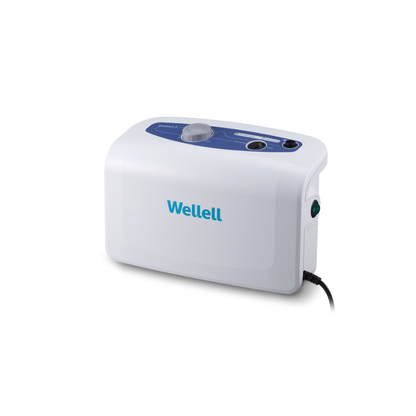The Wellell Domus 3 Bariatric Alternating Pressure Mattress with Micro Low Air Loss is a white medical device with the Wellell brand on the front and a blue control panel on top. It helps prevent pressure ulcers in long-term care, with a right-side power cord connection.
