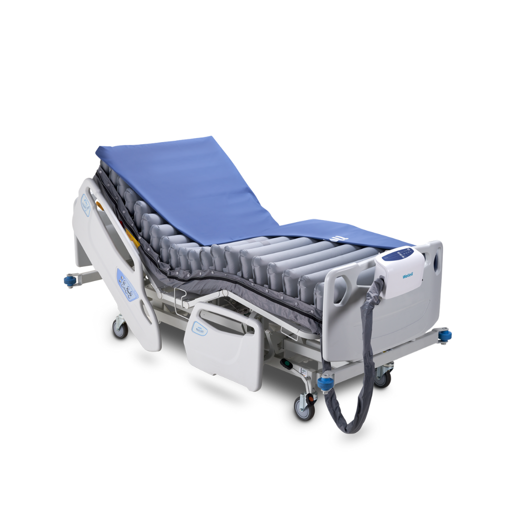 The Wellell Domus 4 Bariatric Alternating Pressure Mattress with Micro Low Air Loss features an adjustable blue mattress, side rails, corded control unit, wheels, and segmented air tubes for pressure ulcer prevention.