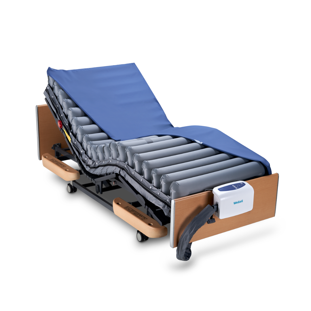 The Wellell Domus 4 Bariatric Alternating Pressure Mattress with Micro Low Air Loss features an adjustable bed, blue air mattress, wooden head/footboards, wheels for mobility, and electronic controls to help prevent pressure ulcers.